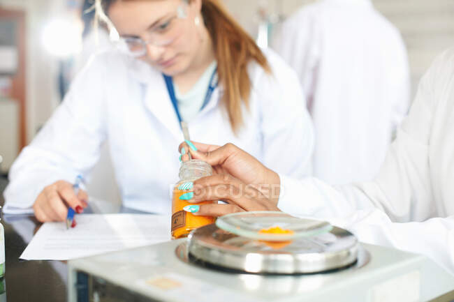 Estudiantes de química que pesan productos químicos en básculas - foto de stock