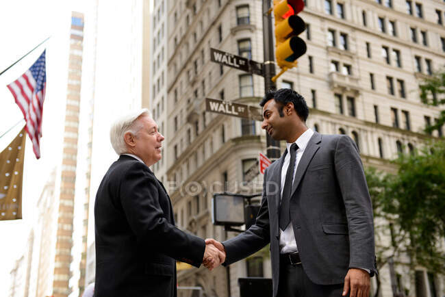 Empresários apertando as mãos em Wall Street, Nova York — Fotografia de Stock