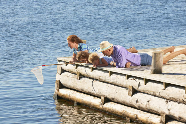 Pesca di famiglia con rete su pontile di legno — Foto stock