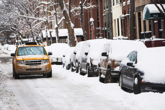Taxi driving on snowy street — Stock Photo