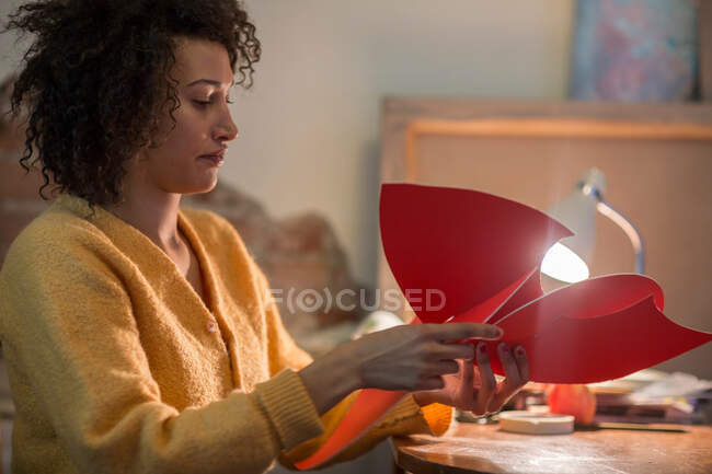 Mulher dobrando papelão vermelho — Fotografia de Stock