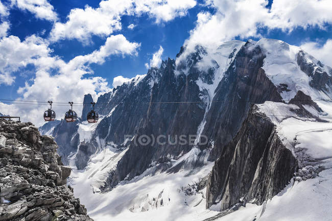 Cable cars running over snow covered mountain valley — Stock Photo