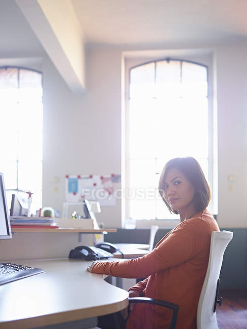 Жінка-офіс працівник сидить за столом — стокове фото