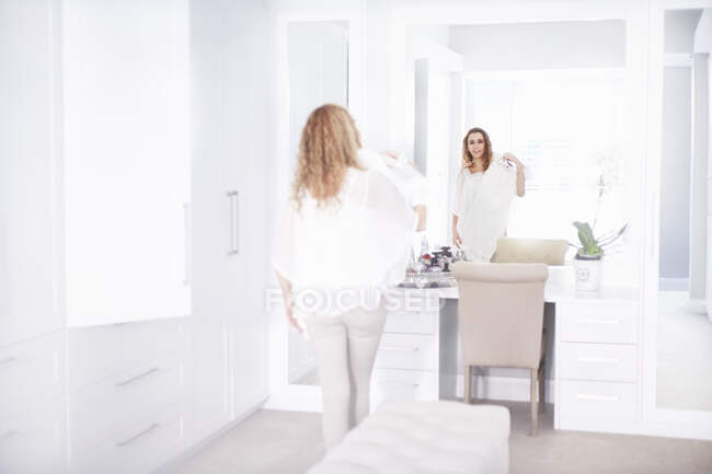 Young woman getting ready in bedroom mirror — Stock Photo