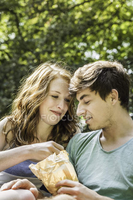 Молодая пара делится мешком еды — стоковое фото