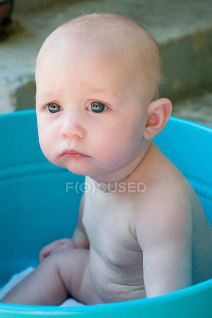 Menino sentado em balde — Fotografia de Stock