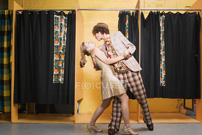 Retro couple dancing in clothes store — Stock Photo