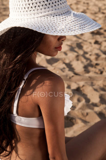 Mulher na praia usando chapéu de sol branco — Fotografia de Stock
