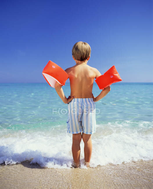 Boy paddling with arm bands — Stock Photo