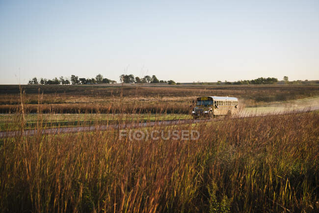 School bus traveling along dusty rural road, Missouri, USA — Stock Photo