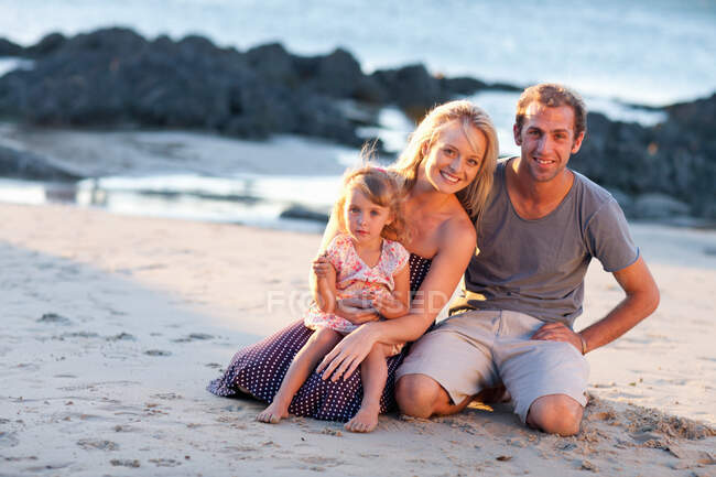 Família jovem com filha na praia — Fotografia de Stock