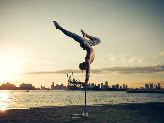 Mature man doing handstand on pole, South Pointe Park, South Beach, Miami, Florida, USA — Stock Photo