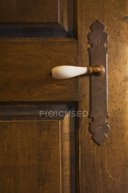 Крупный план белой фарфоровой дверной ручки на старой деревянной двери в главной спальне на верхнем этаже дома 2003 года постройки коттеджного типа, Квебек, Канада. Это изображение является собственностью освобожденной. CUPR0244 — стоковое фото