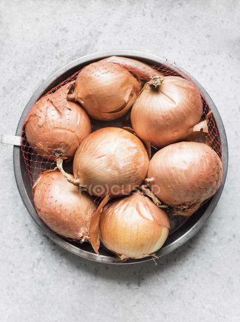Raw onions in net — Stock Photo