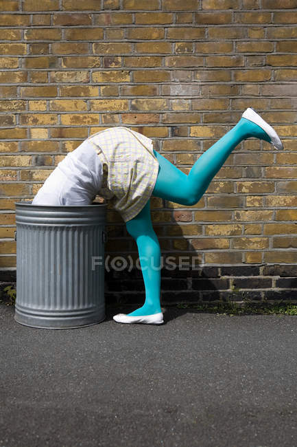 Woman looking in a dustbin — Stock Photo