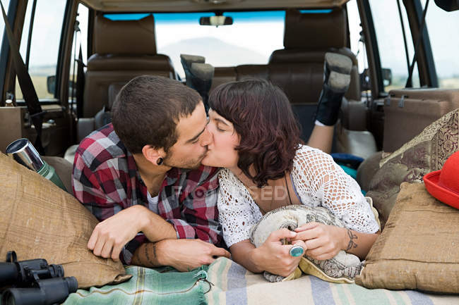 Jovem casal beijando na parte de trás do suv — Fotografia de Stock