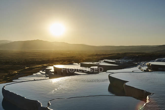 Setting sun over hot spring terraces — Stock Photo