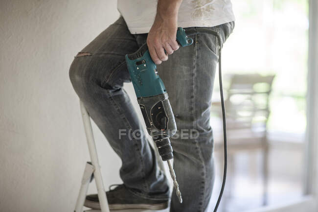 Cape Town, South Africa man with drill on a ladder — Stock Photo