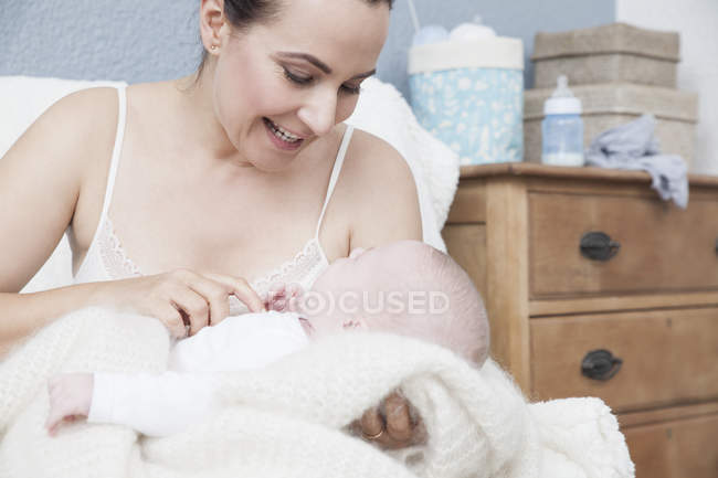 Madre cosquillas bebé niño y sonriendo - foto de stock