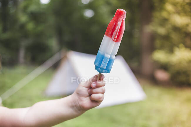 Hand holding a red marker on a stick — Stock Photo