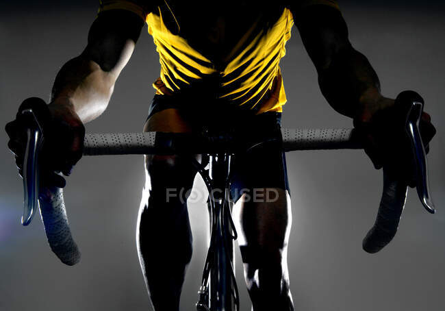 Hombre en bicicleta sobre fondo oscuro - foto de stock