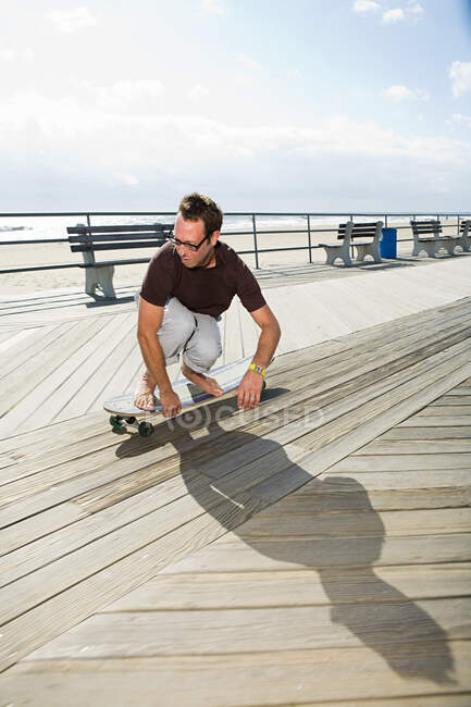 Homme skateboard sur boardwalk — Photo de stock