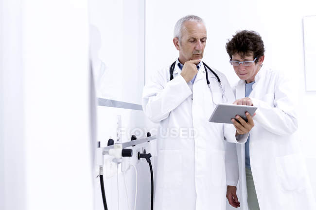 Dos médicos mirando la tableta digital - foto de stock