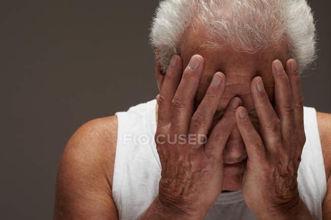 Hombre mayor con la cabeza en las manos - foto de stock