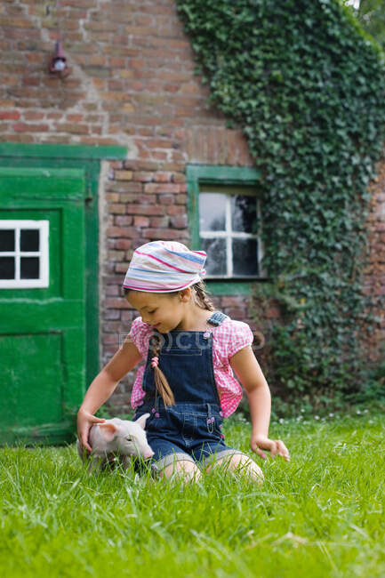 A girl and a piglet — Stock Photo