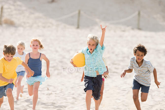 Niños corriendo por la playa - foto de stock