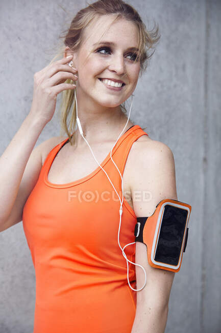 Mujer con tecnología portátil y auriculares - foto de stock