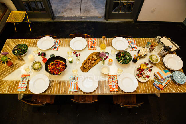 Table à manger pour six personnes avec une variété de plats — Photo de stock