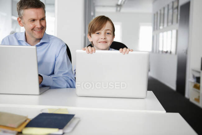 Père et fils utilisant des ordinateurs portables — Photo de stock