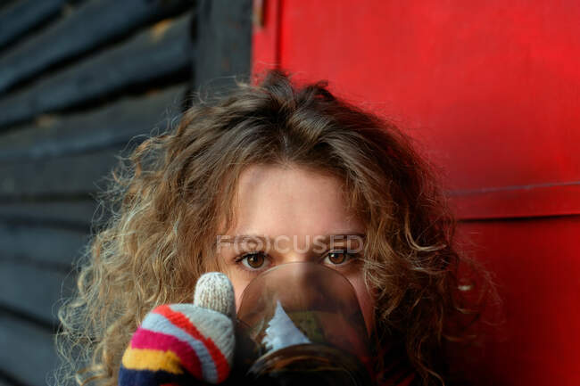 Frau in Handschuhen trinkt — Stockfoto