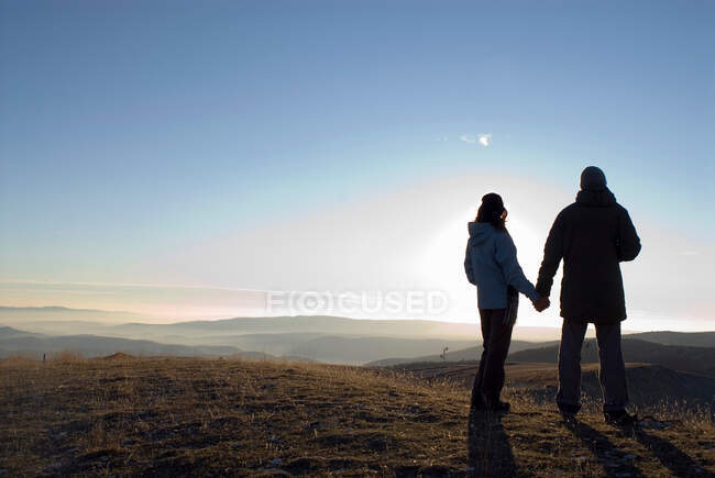 Пара тримає руки на гірському пагорбі — стокове фото