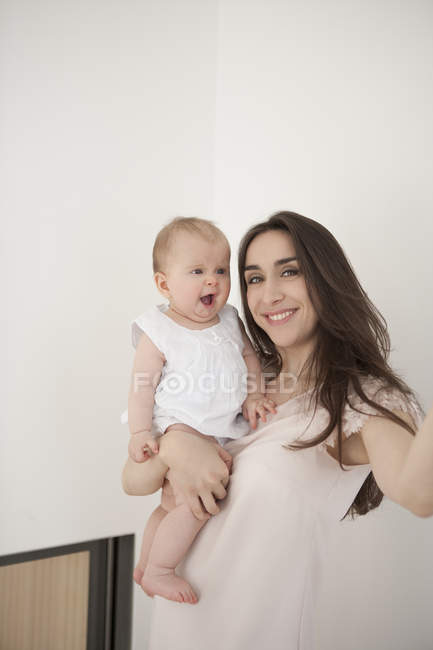 Mother carrying yawning baby — Stock Photo