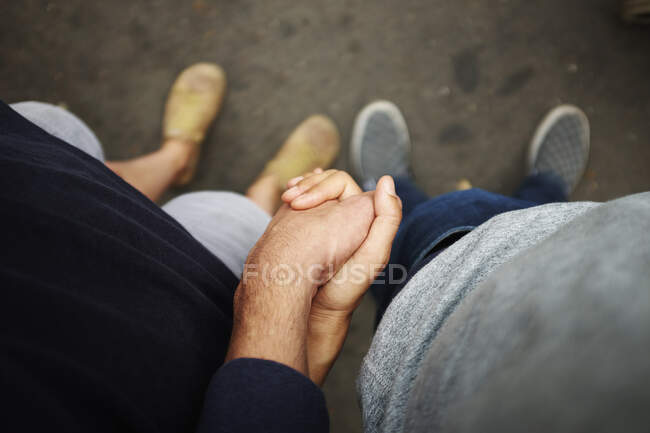 Overhead view of couple holding hands — Stock Photo