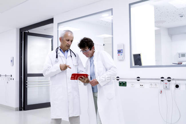 Dois médicos olhando para tablet digital — Fotografia de Stock