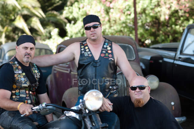 Hombres sentados alrededor de la motocicleta - foto de stock