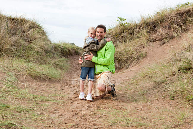 Padre e hija en una duna - foto de stock