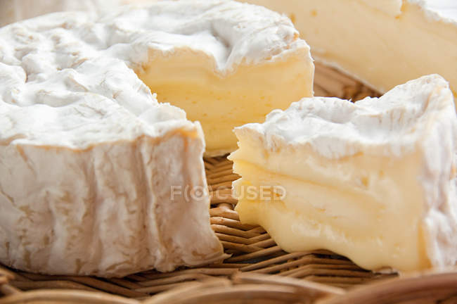 Camembert cheese in straw basket, close up shot — Stock Photo
