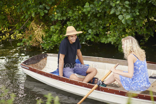 Young couple rowing river rowing boat — Stock Photo