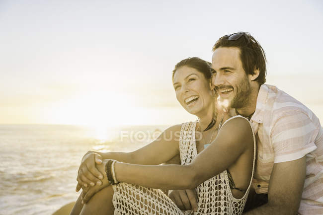 Mid adult couple sitting on beach at sunset, Cape Town, South Africa — Stock Photo