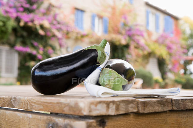 Close-up view of fresh ripe organic aubergines on table, selective focus — Stock Photo