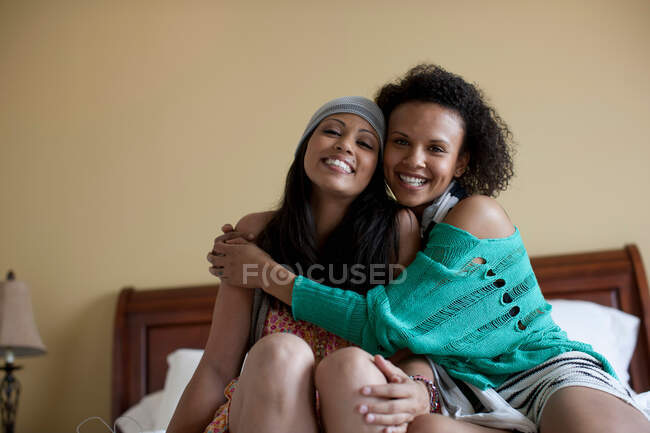 Young women embracing on bed, portrait — Stock Photo