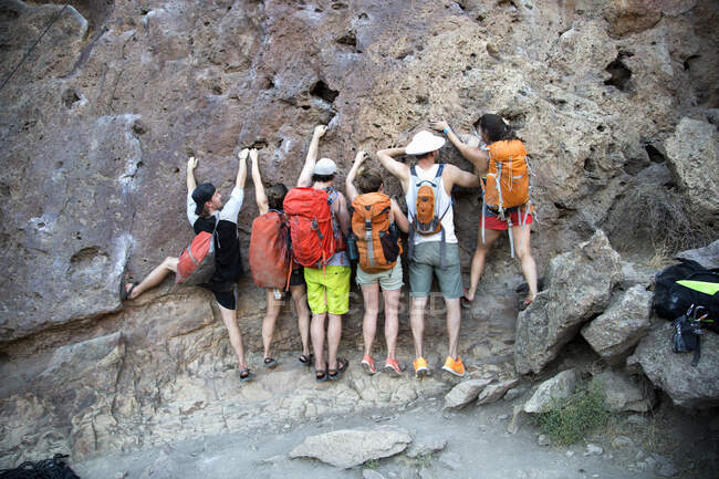 Grupo de amigos escalando en la roca - foto de stock