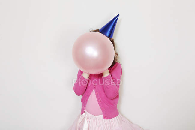Girl holding pink balloon in front of face — Stock Photo
