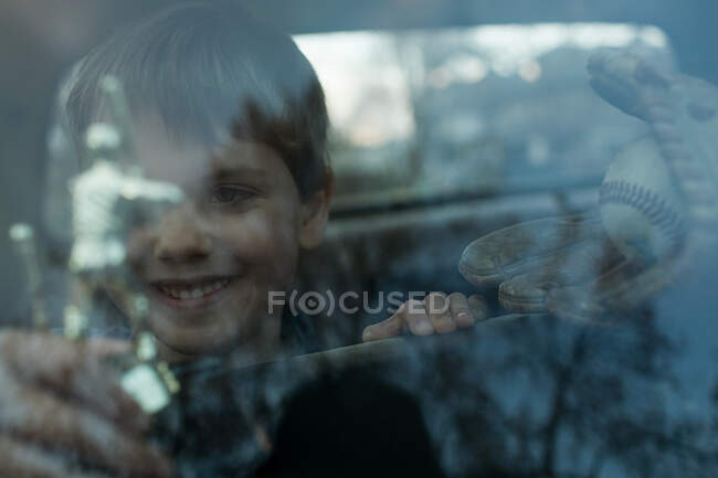 Мальчик с трофеем через окно — стоковое фото