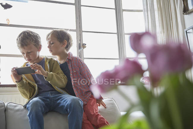 Two little brothers using smartphone at home — Stock Photo
