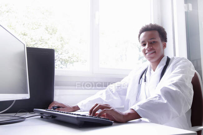 Scientist wearing lab coat working on computer — Stock Photo
